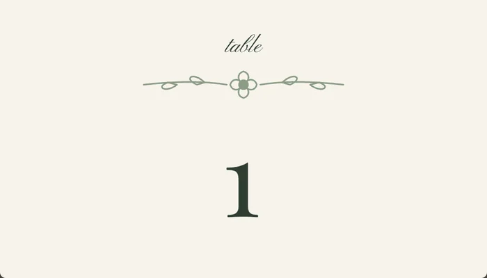 A wedding table number card with the number in script and a botanical divider